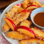 Delicious air fryer apple fries served with a sprinkle of cinnamon on a plate