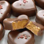 A plate of chocolate peanut butter hearts adorned with sprinkles, perfect for Valentine's Day.