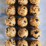 Close-up of healthy no-bake protein balls on a plate, surrounded by oats and chocolate chips, perfect for a nutritious snack or breakfast.