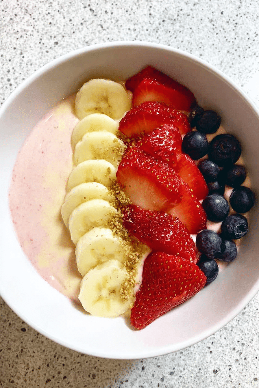 5-minute fruit smoothie bowl with toppings of sliced bananas, blueberries, granola, and chia seeds, showcasing vibrant colors.