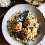Baked sage chicken meatballs on creamy parmesan orzo with crispy sage garnish.