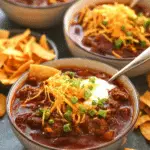 Delicious beef chili topped with cheddar cheese and green onions, served with Fritos.