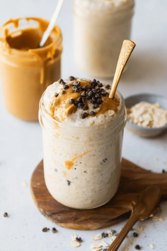 Close-up of blended overnight oats topped with fruits and nuts in a mason jar.