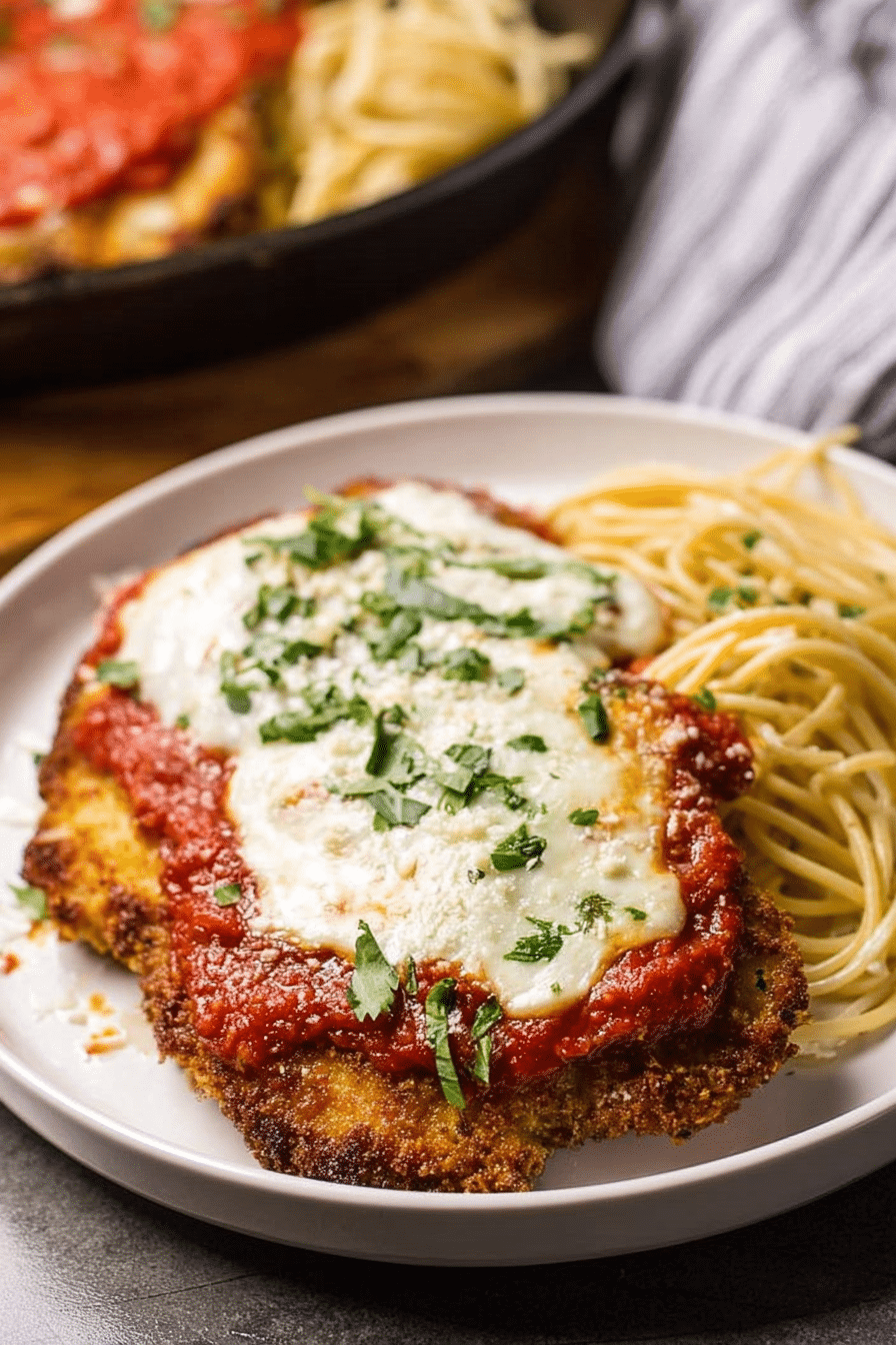 Classic veal parmesan topped with mozzarella cheese and served with pasta.
