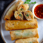 Crispy Chinese spring rolls served with dipping sauce on a plate