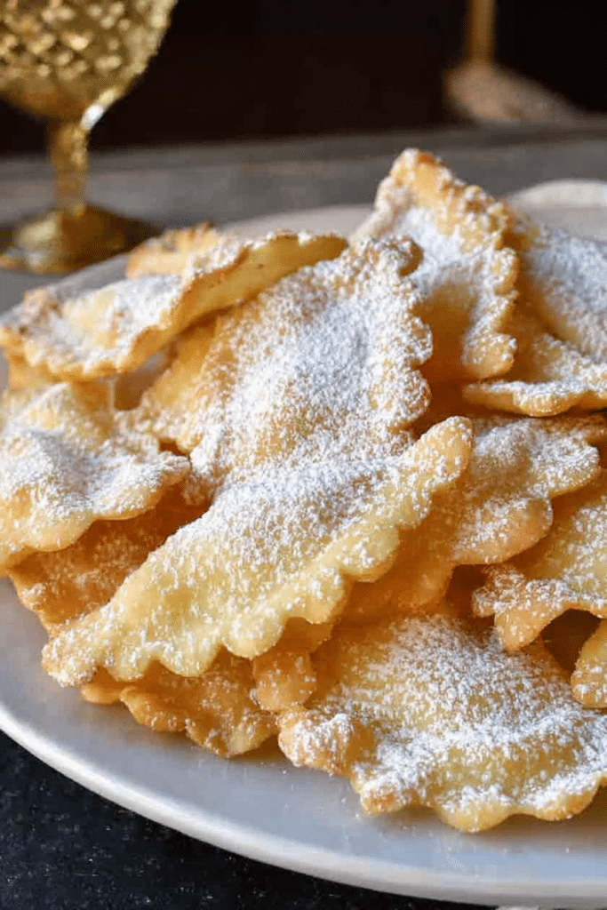 A festive platter of crispy fried Italian crostoli cookies dusted with powdered sugar.