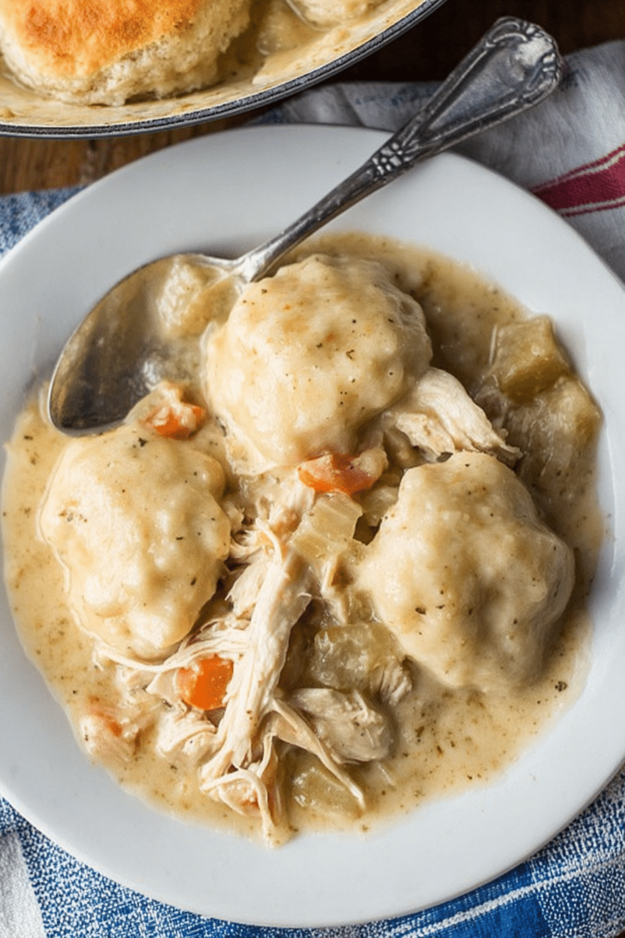 Delicious bowl of easy chicken and dumplings with biscuits, garnished with herbs