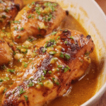 Delicious easy honey mustard chicken garnished with parsley and lemon slices on a rustic table.