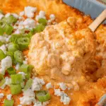 Delicious Frank's RedHot Buffalo Chicken Dip garnished with green onions, surrounded by tortilla chips.