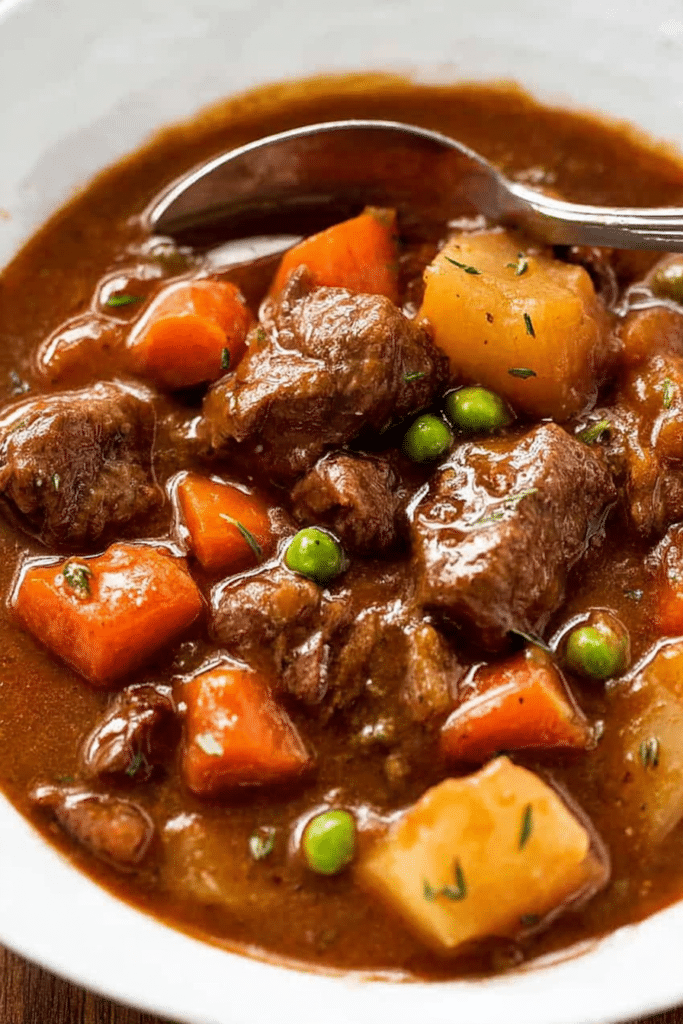 Delicious slow cooker beef stew with carrots and potatoes in a rustic bowl, garnished with fresh herbs.