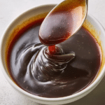 Homemade teriyaki sauce drizzled over grilled chicken with sesame seeds and green onions.