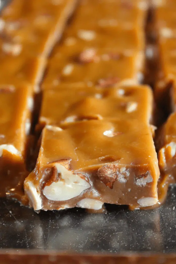 Oklahoma Nut Candy squares with walnuts and pecans on a rustic wooden table