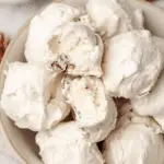 Close-up of old-fashioned divinity candy pieces on a decorative plate, highlighting their fluffy texture and gloss.