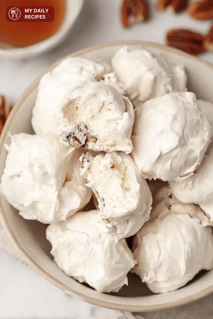 Close-up of old-fashioned divinity candy pieces on a decorative plate, highlighting their fluffy texture and gloss.