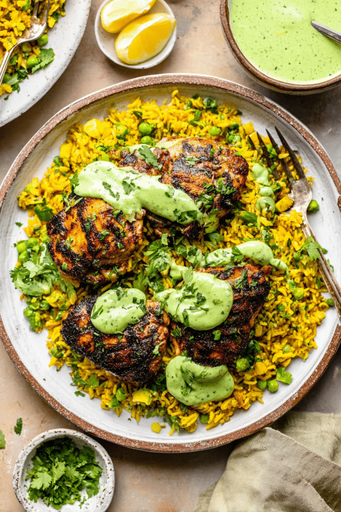 Delicious Peruvian Chicken and Rice served with green sauce, garnished with cilantro