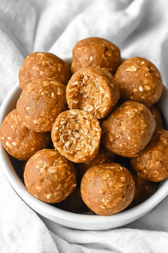 Plate of pumpkin protein balls garnished with pumpkin pie spice and almonds, showcasing a delicious snack option.