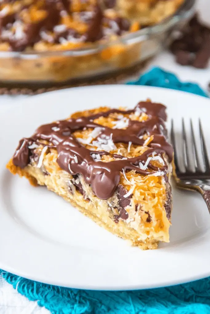 Delicious Samoa Cookie Pie slice showcasing chocolate, caramel, and toasted coconut layers on a wooden table.