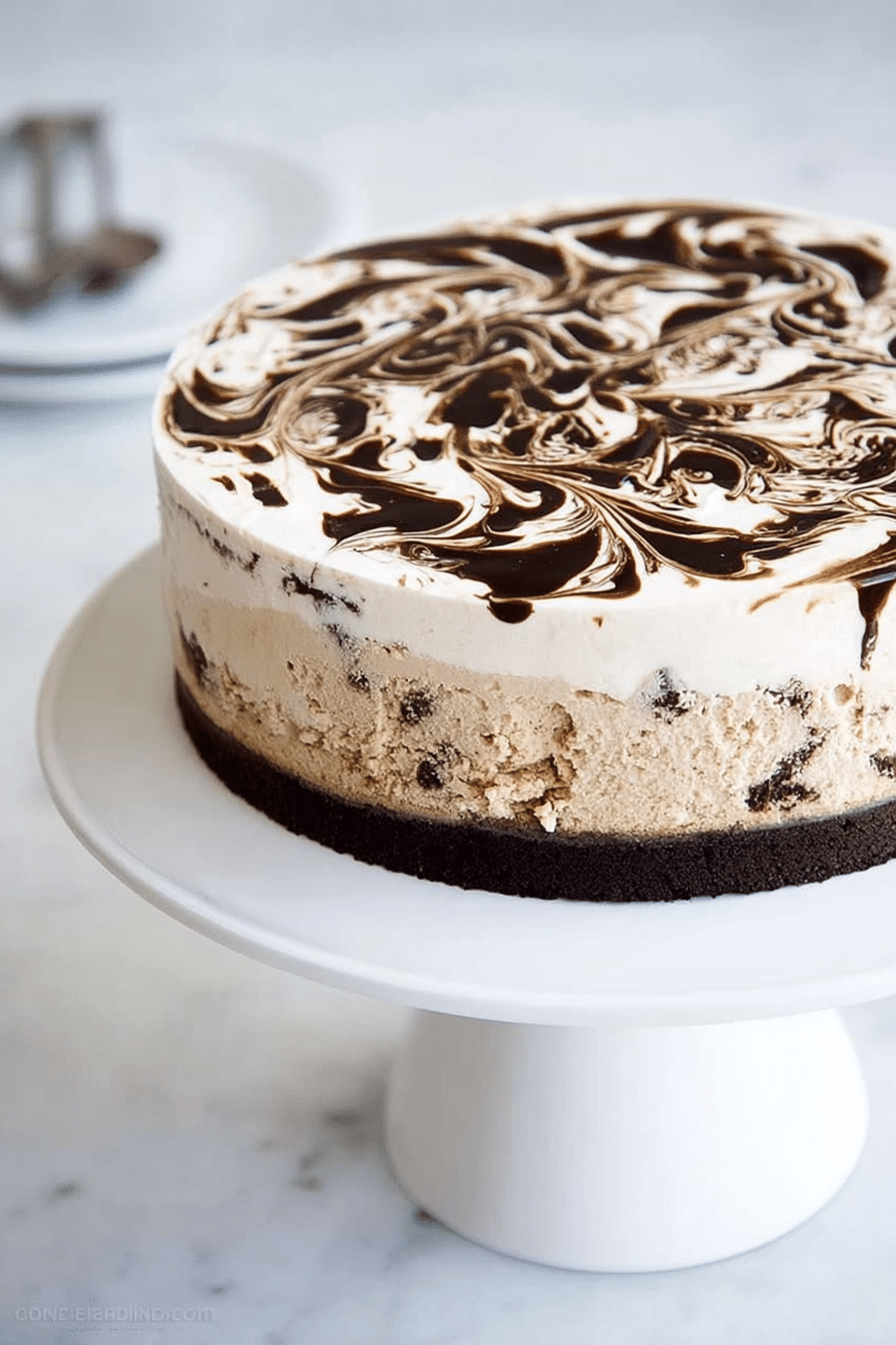 Slice of coffee ice cream cake featuring brownie base, creamy coffee ice cream filling, and a fudge swirl on a rustic wooden table.