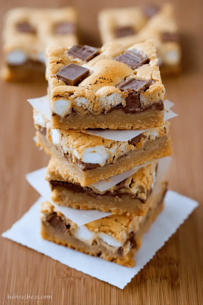 Delicious s'mores bars with melted chocolate and marshmallows on a white plate.