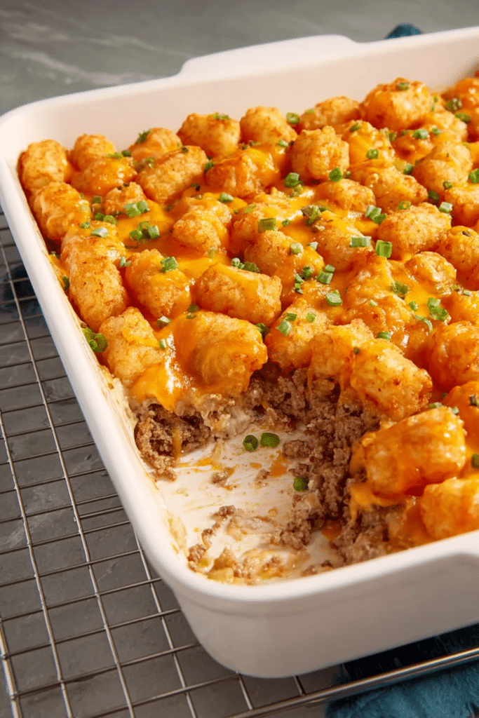 Golden brown Tater Tot casserole with melted cheese and tater tots on top, served in a colorful baking dish.