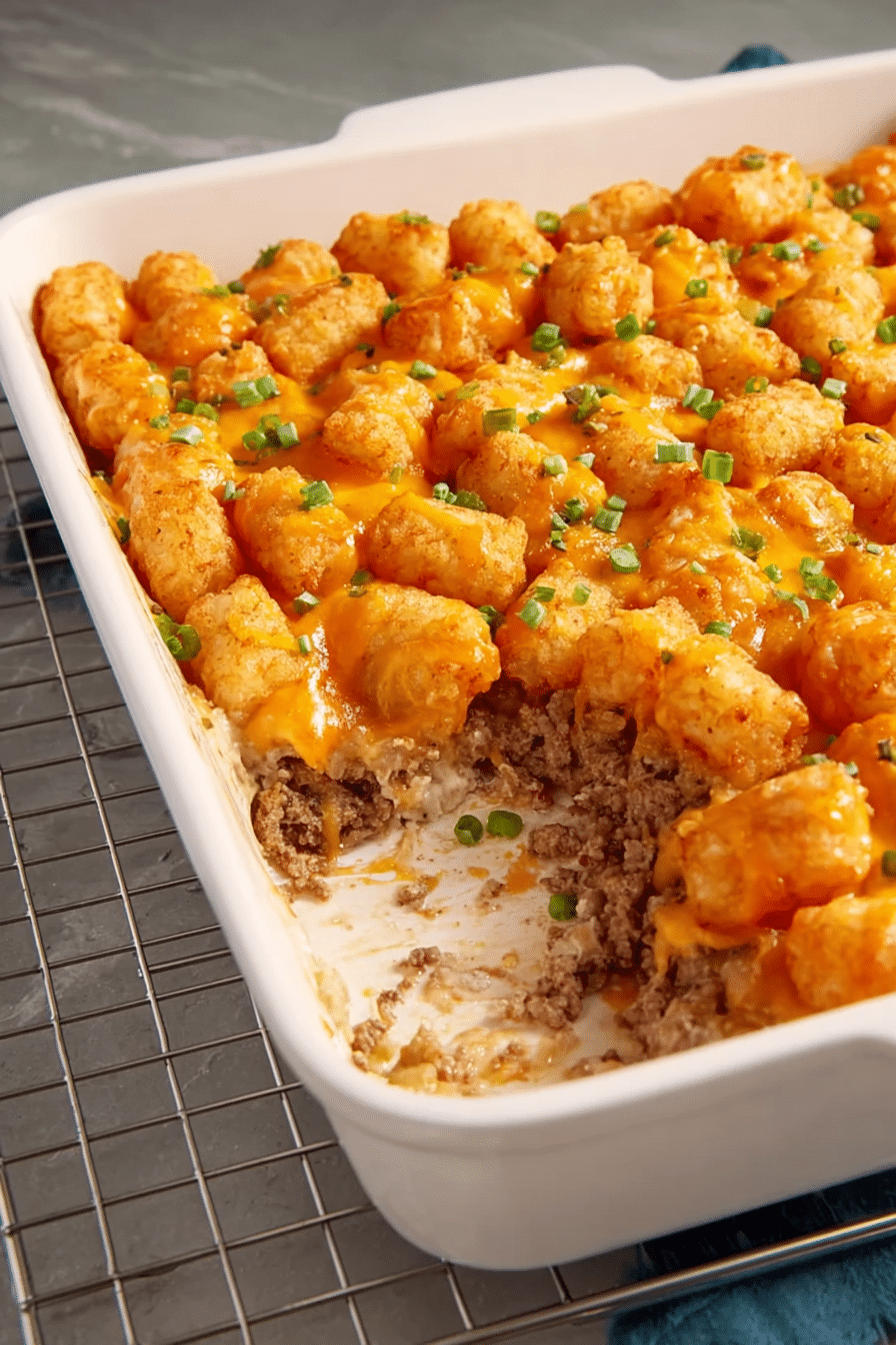 Golden brown Tater Tot casserole with melted cheese and tater tots on top, served in a colorful baking dish.