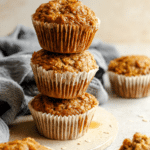 Freshly baked ABC muffin with apple, banana, and carrot ingredients displayed around it.