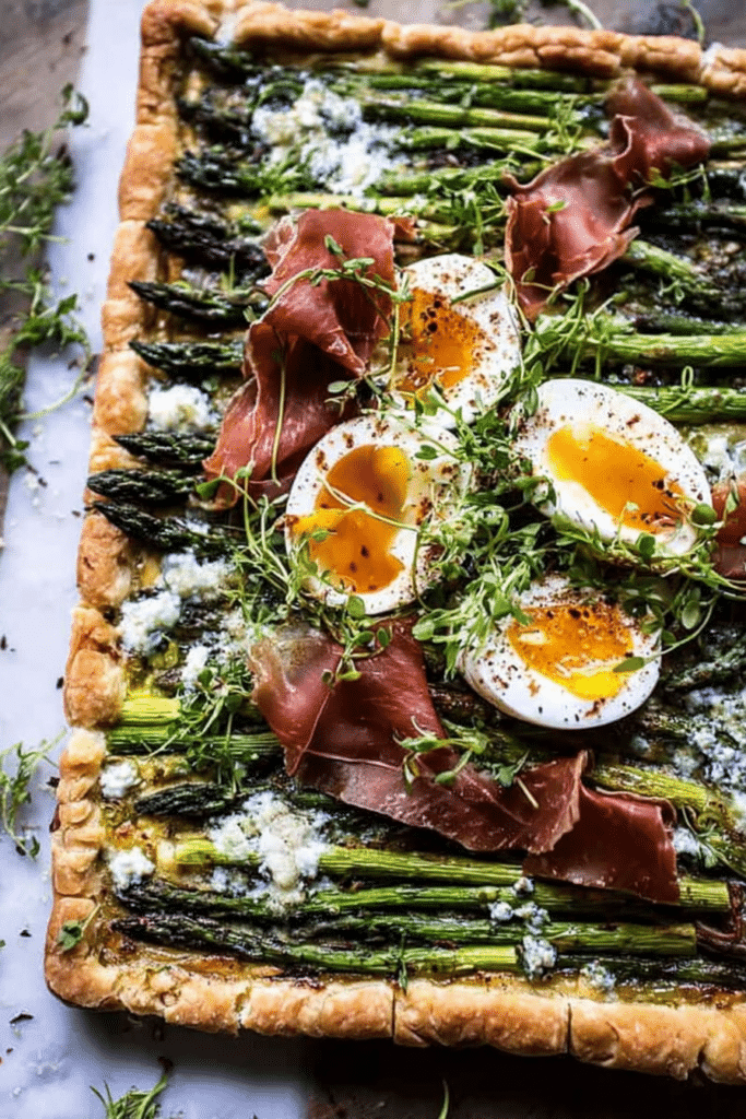 Asparagus egg and prosciutto tart served with arugula salad and lemon slices