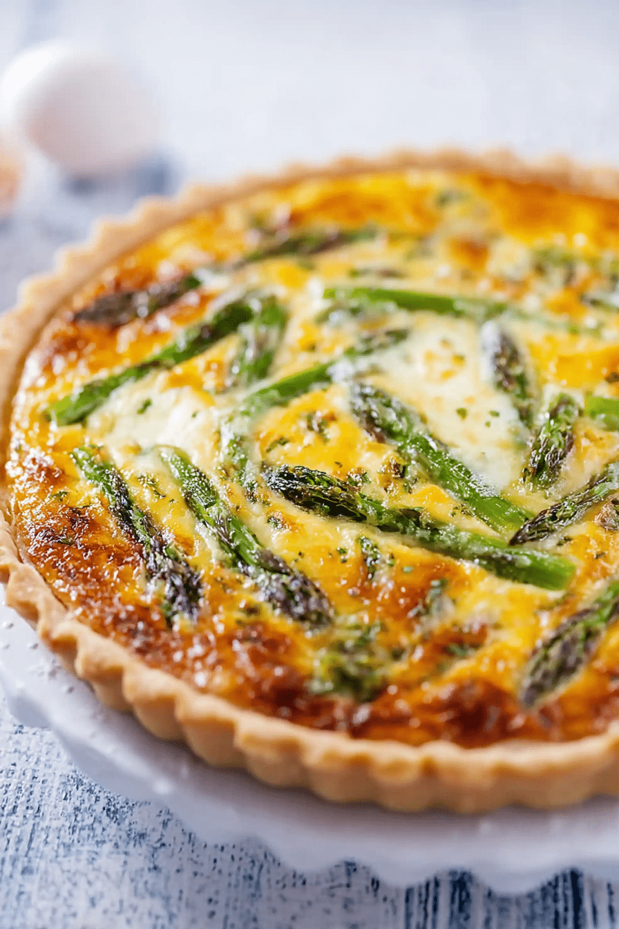 Sliced asparagus quiche with green asparagus and feta cheese on a wooden table
