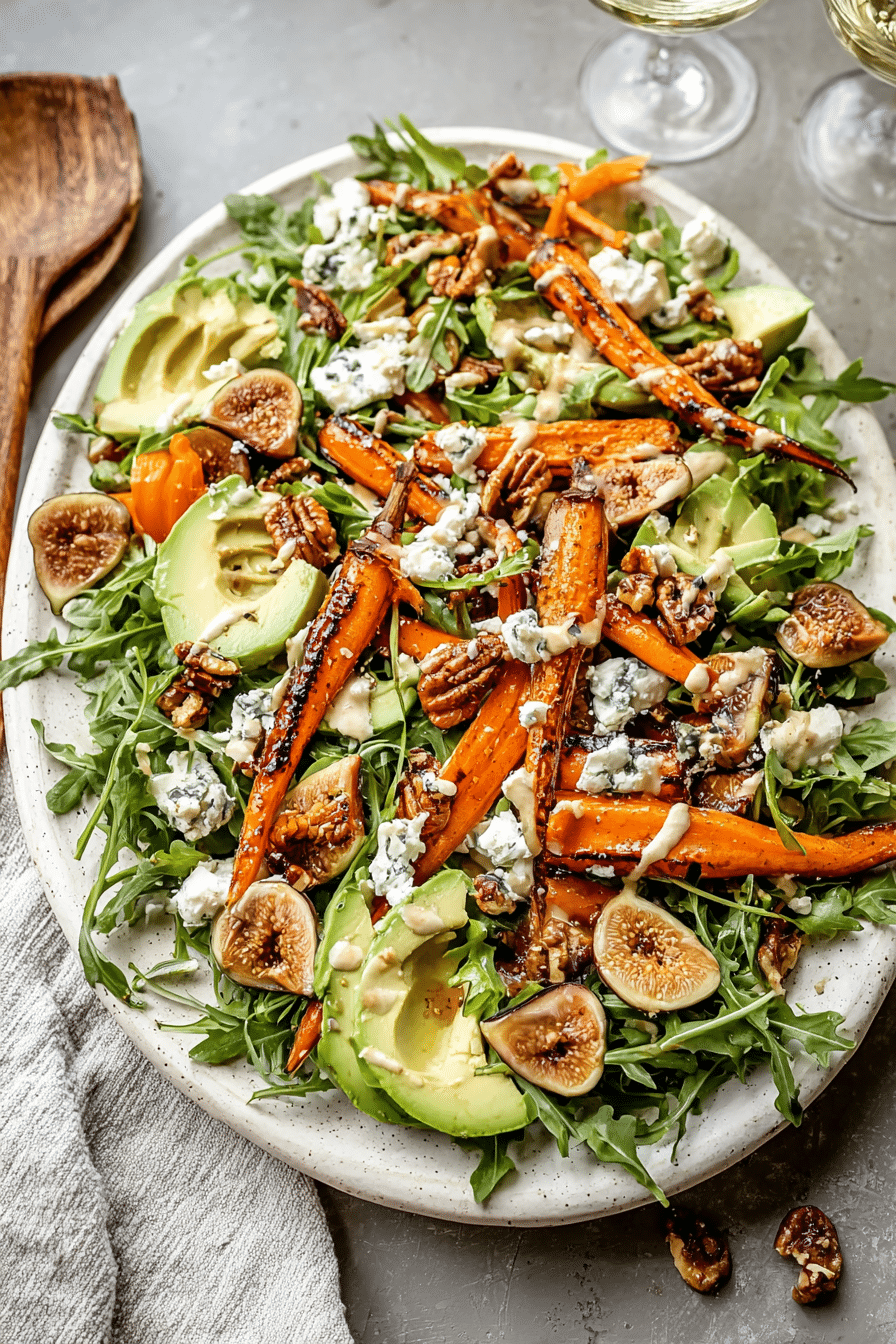 Delicious carrot arugula salad with grilled carrots, avocado, figs, goat cheese, and walnuts drizzled with tahini dressing.