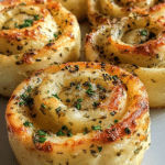 Delicious cheesy garlic butter rollups served with marinara sauce and fresh parsley on a wooden board.