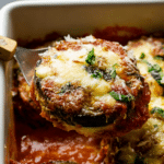 Delicious classic eggplant parmesan served with fresh herbs on top.