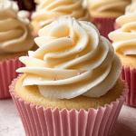 Delicious copycat Magnolia Bakery cupcakes with fluffy buttercream frosting and colorful sprinkles on a white plate.
