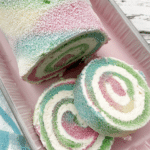 Easter Cake Roll decorated with pastel colors and powdered sugar on a festive plate.