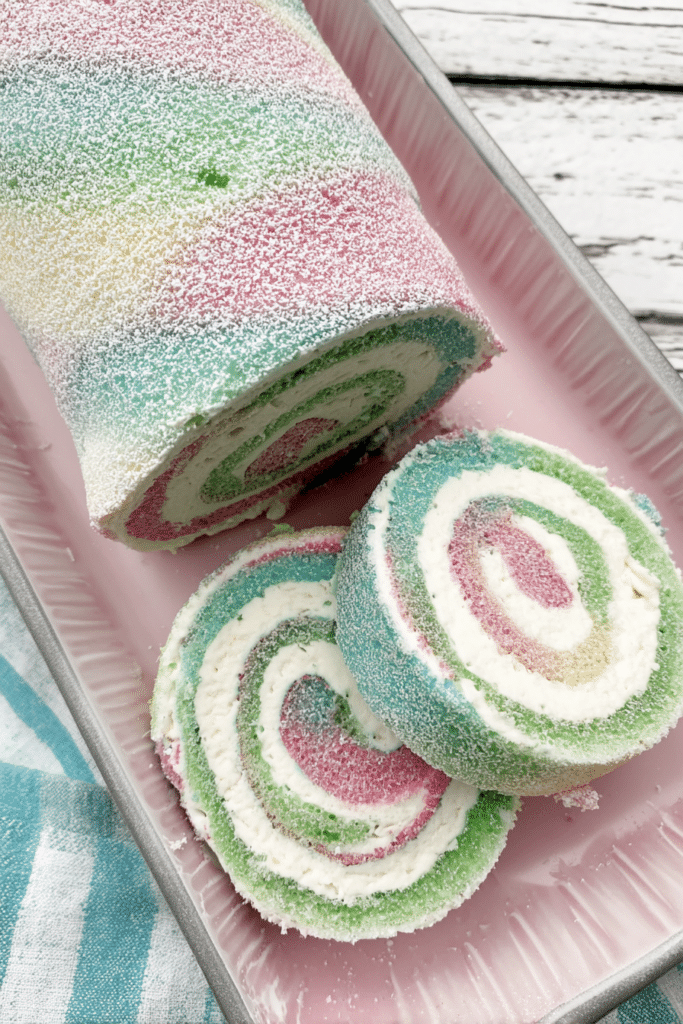 Easter Cake Roll decorated with pastel colors and powdered sugar on a festive plate.