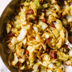 Close-up of easy fried cabbage with bacon and herbs in a skillet