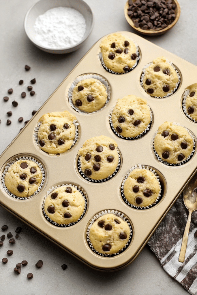 Fluffy chocolate chip yogurt muffins with chocolate chips and maple syrup on a wooden table