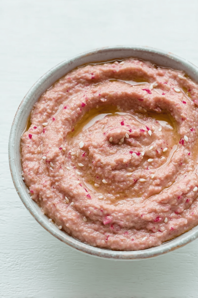 Fresh radish hummus served with pita bread and colorful vegetables for dipping.