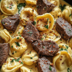 Delicious garlic steak tortellini served in a bowl, featuring creamy parmesan sauce and garnished with fresh parsley.