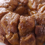 Close-up of delicious easy monkey bread with gooey caramel and cinnamon sugar, pulled apart to reveal layers.