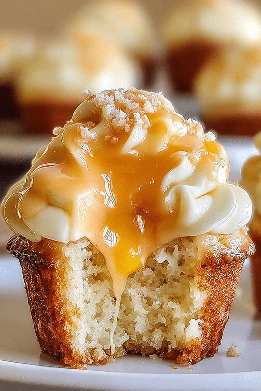 Delicious honey peach cream cheese cupcakes with peach slices and honey drizzle on a wooden table.
