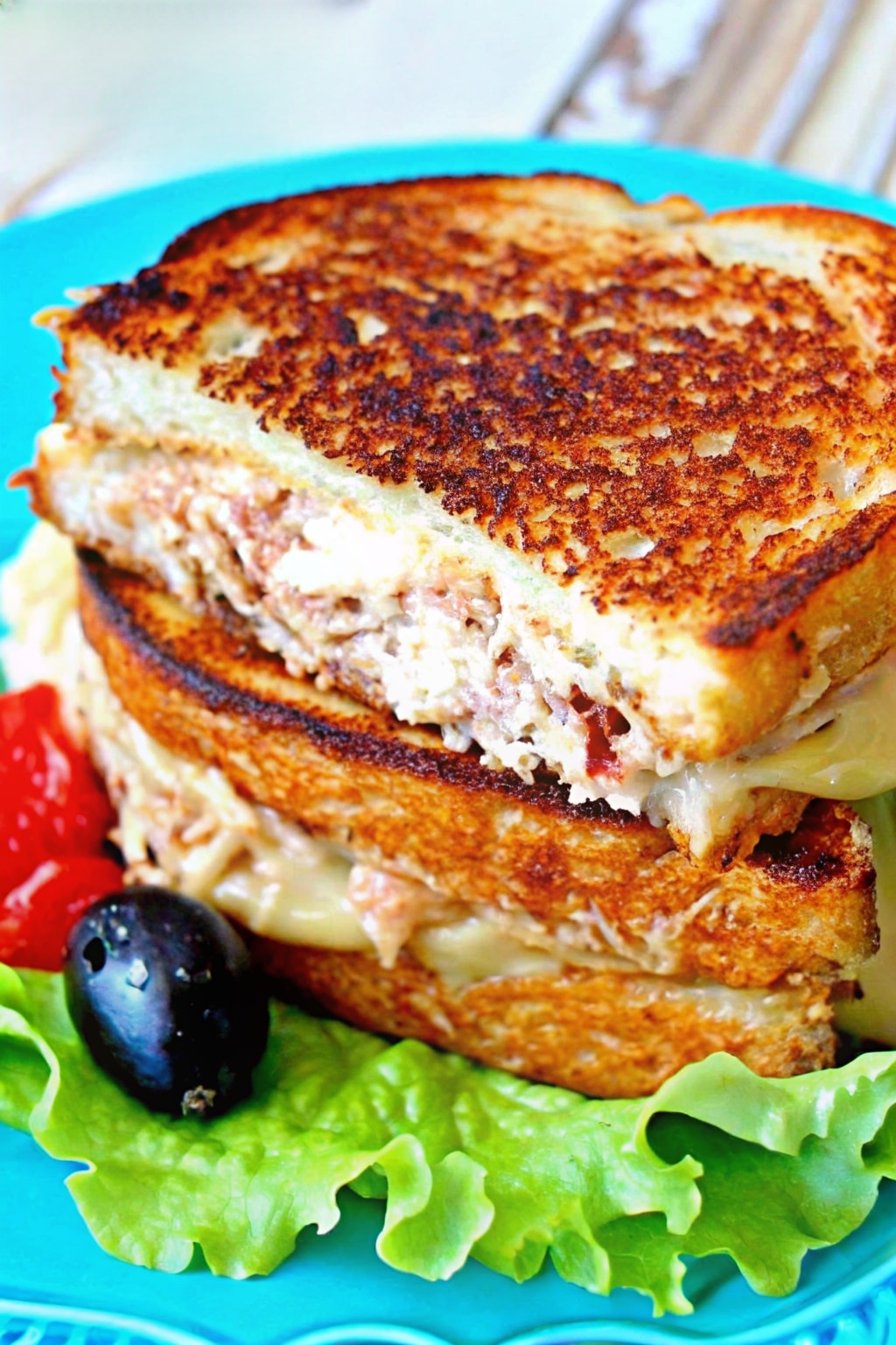 The perfect tuna melt with golden toasted bread and melted mozzarella cheese, sliced in half to reveal the creamy tuna filling.