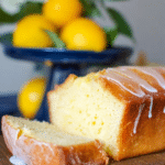 Lemon pound cake served on a wooden table with lemon slices and fresh mint, perfect for summer brunch.