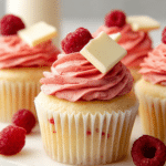Close-up of a raspberry and white chocolate cupcake with raspberry buttercream and white chocolate ganache.