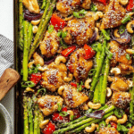 Sheet pan sesame chicken with vibrant vegetables and fresh herbs, perfect for a weeknight dinner.