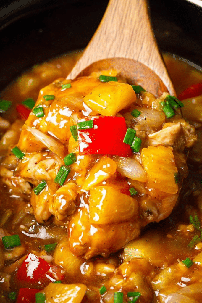 Delicious Slow Cooker Hawaiian Chicken served with rice and colorful vegetables, garnished with sesame seeds and green onions.
