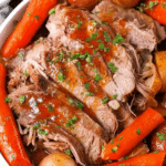 Delicious Slow Cooker Yankee Pot Roast served with carrots and potatoes on a wooden table
