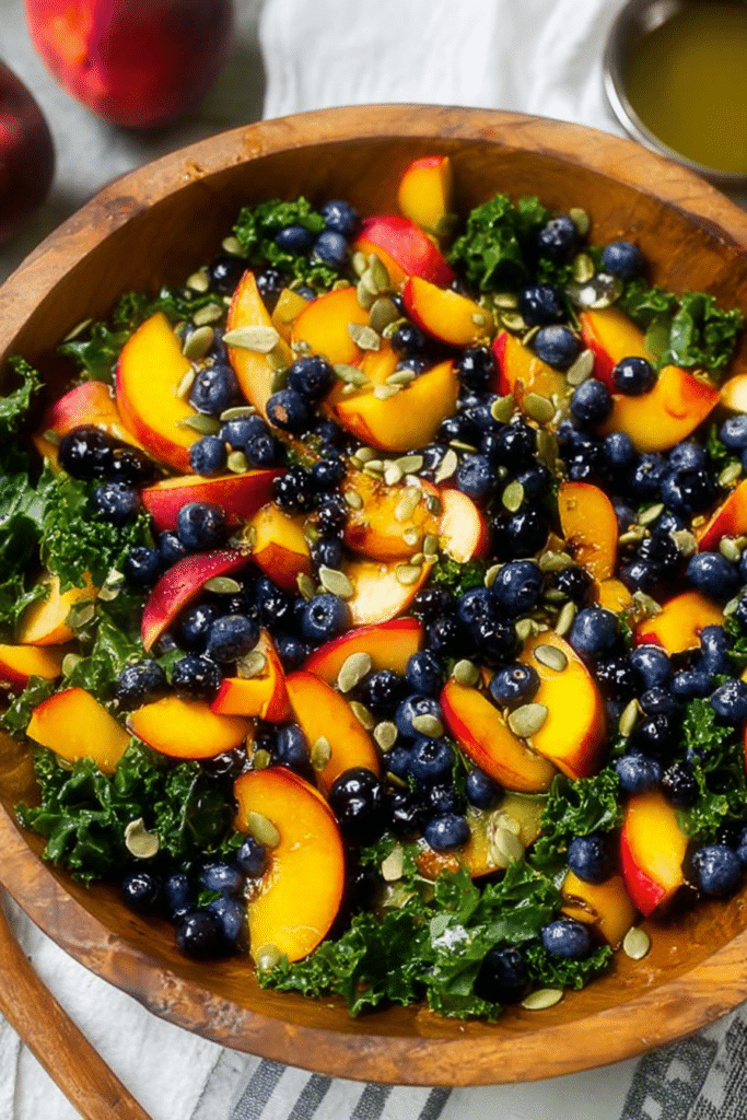 Bright summer peach blueberry kale salad with toasted pepitas in a rustic bowl, perfect for summer meals.