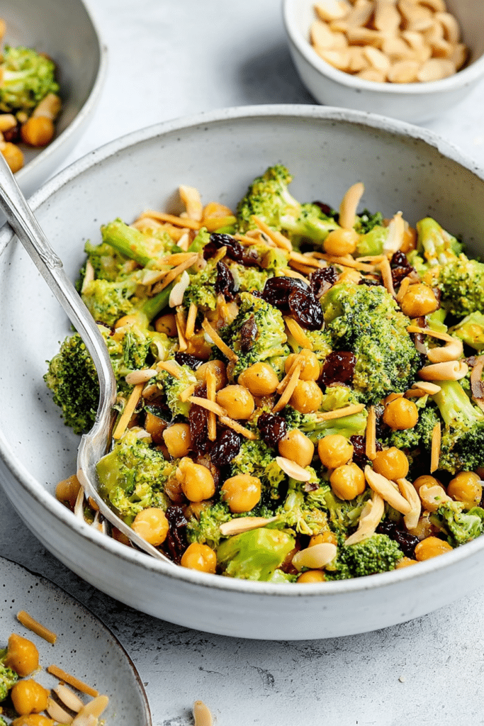 Vegan curried broccoli chickpea salad with colorful vegetables and a tahini dressing in a bowl.