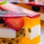Vibrant agar jelly fruit cake with tropical fruit pieces on a plate, perfect for summer parties.