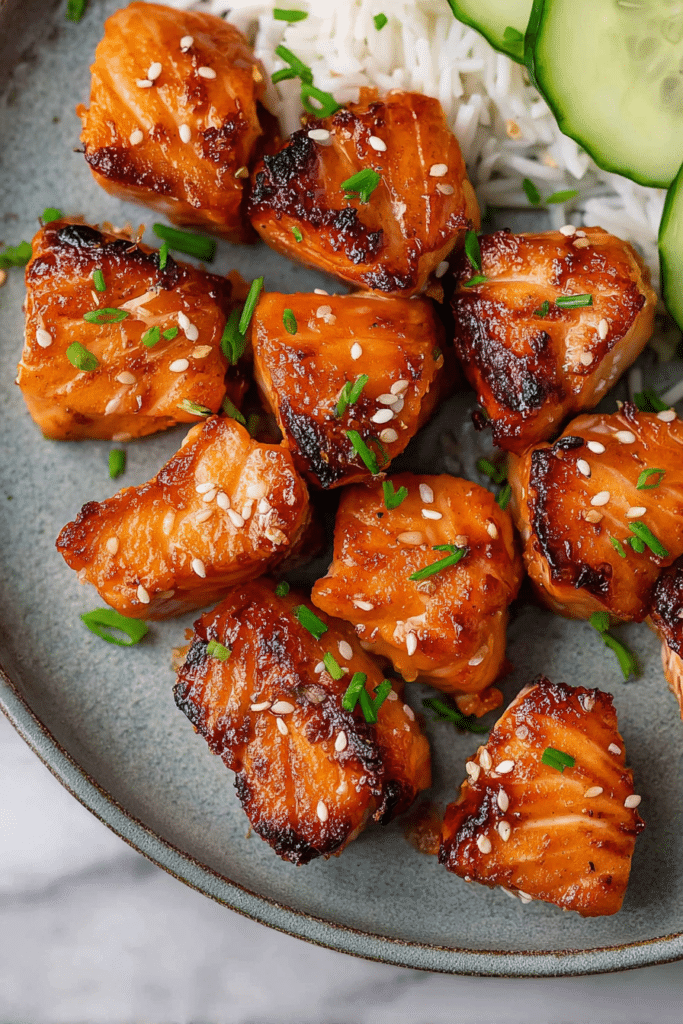 Delicious air fryer salmon bites garnished with sesame seeds and served in a colorful bowl, showcasing the savory and sweet flavor.